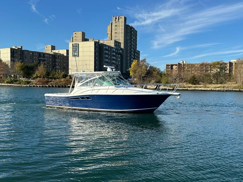 Slide: The Image of 2011 Rampage 34 IPS boat on urban waterfront with buildings in background. - 2