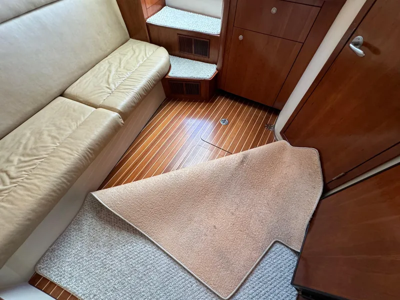 Slide: The Image of Interior of 2011 Rampage 34 IPS boat with wooden flooring and beige seating. - 34