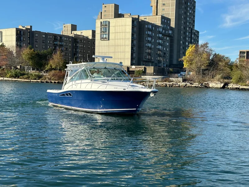 Slide: The Image of 2011 Rampage 34 IPS boat cruising near urban waterfront buildings. - 4