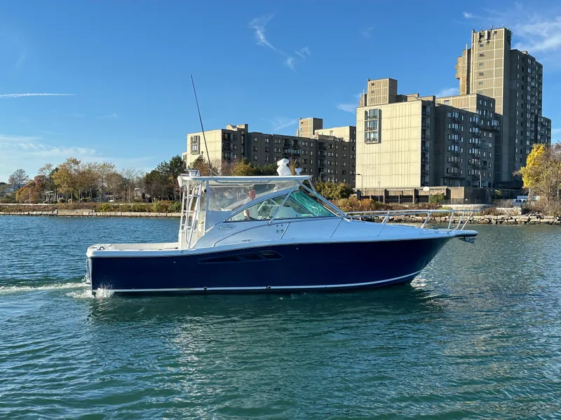 Slide: The Image of 2011 Rampage 34 IPS boat cruising on a sunny day near urban buildings. - 6