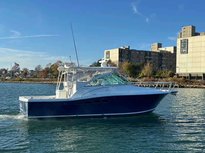 Slide: The Image of 2011 Rampage 34 IPS boat cruising on a sunny day near urban buildings. - 8