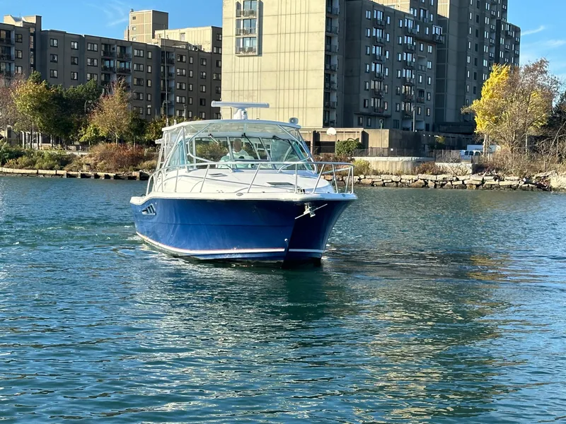 Slide: The Image of 2011 Rampage 34 IPS boat cruising near urban waterfront buildings. - 9