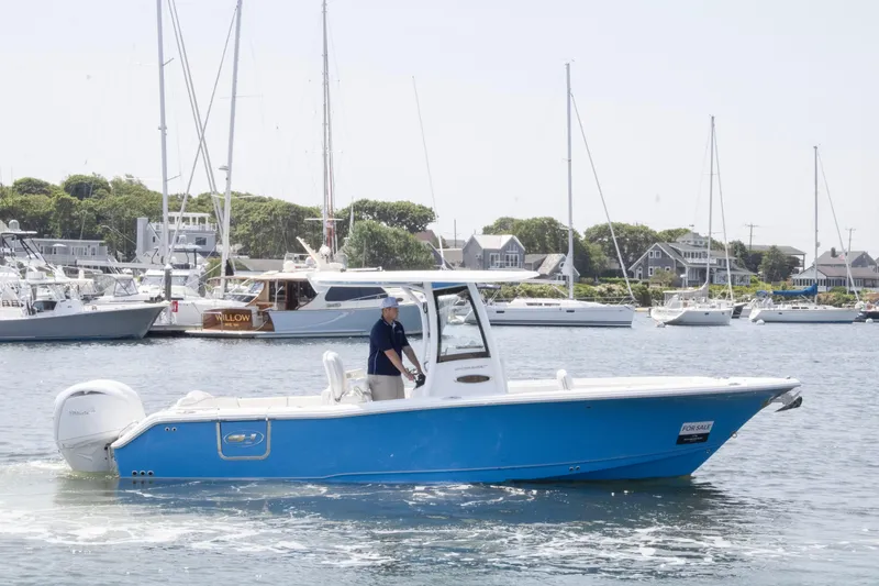 Slide: The Image of 2025 Sea Hunt Ultra 265 SE boat cruising in a marina with sailboats in the background. - 3