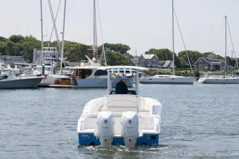 Slide: The Image of 2025 Sea Hunt Ultra 265 SE boat navigating a marina with sailboats and waterfront homes. - 5