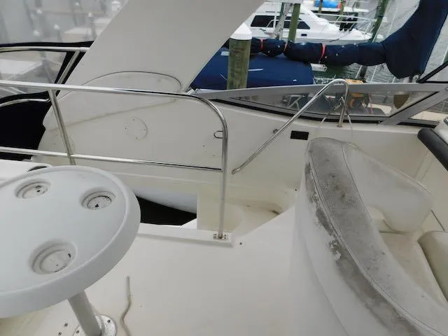 Slide: The Image of 2007 Sea Ray 36 Sedan Bridge interior with seating and table, docked at marina. - 13