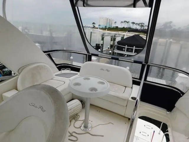 Slide: The Image of 2007 Sea Ray 36 Sedan Bridge interior with seating and table, overlooking marina. - 18