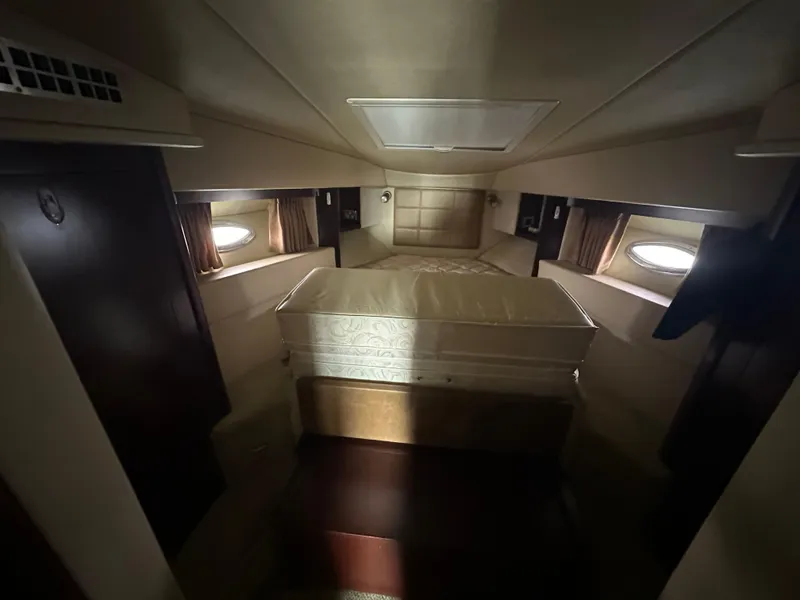 Slide: The Image of Interior cabin of 2007 Sea Ray 36 Sedan Bridge yacht, featuring a cozy bed and porthole windows. - 25