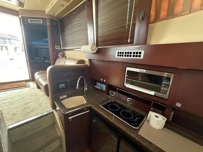 Slide: The Image of 2007 Sea Ray 36 Sedan Bridge interior with kitchen, sink, and microwave. - 31