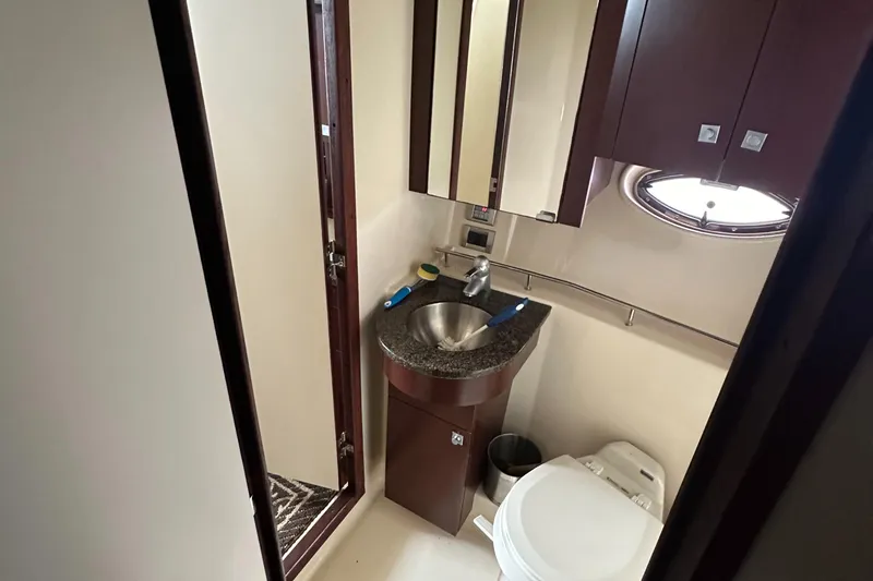Slide: The Image of 2007 Sea Ray 36 Sedan Bridge bathroom with sink, toilet, and storage cabinets. - 32