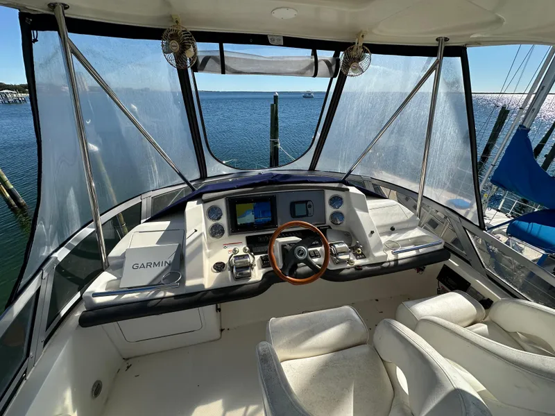 Slide: The Image of 2007 Sea Ray 36 Sedan Bridge helm with Garmin navigation, overlooking serene waters. - 42