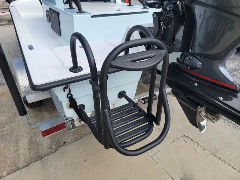 Slide: The Image of 2025 Shallow Sport 18 Sport boat with black swim ladder and outboard motor. - 10