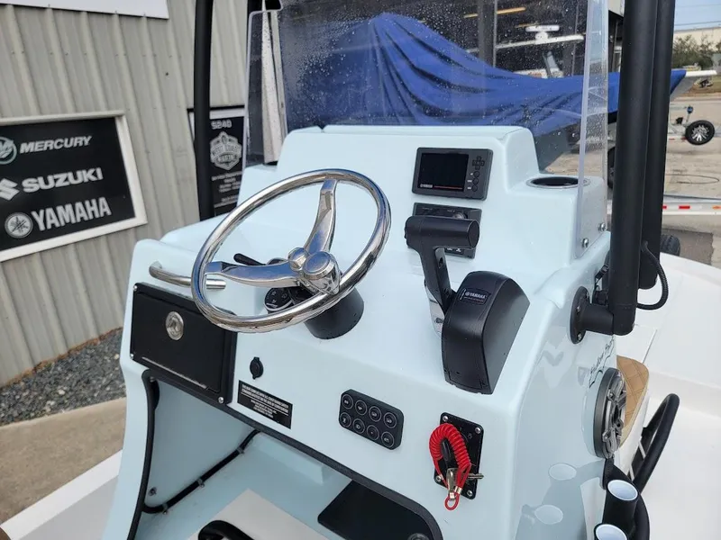 Slide: The Image of 2025 Shallow Sport 18 Sport boat console with steering wheel and controls. - 13