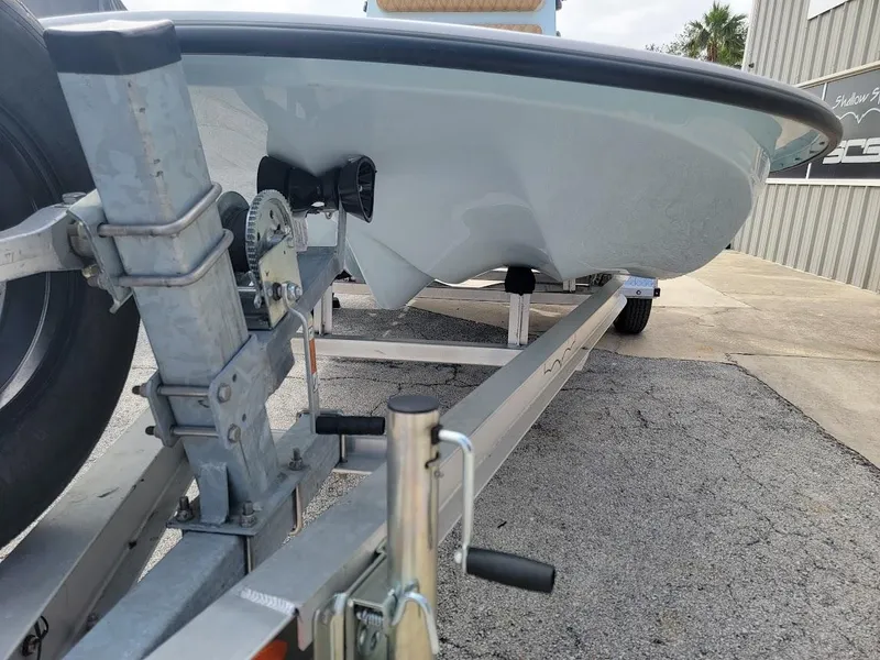 Slide: The Image of 2025 Shallow Sport 18 Sport boat on trailer, close-up view of hull and trailer components. - 15
