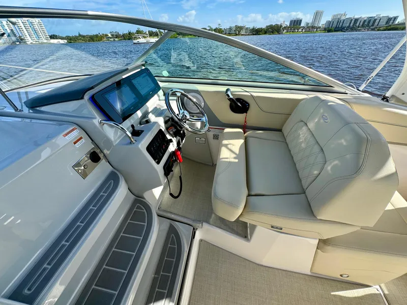 Slide: The Image of 2023 Regal 26 XO boat interior with helm, steering wheel, and seating by the water. - 21