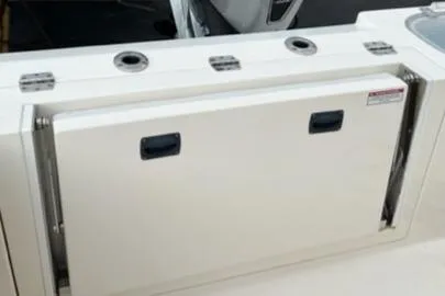 Slide: The Image of Cobia 237 Center Console 2020 boat storage compartment with rod holders. - 11