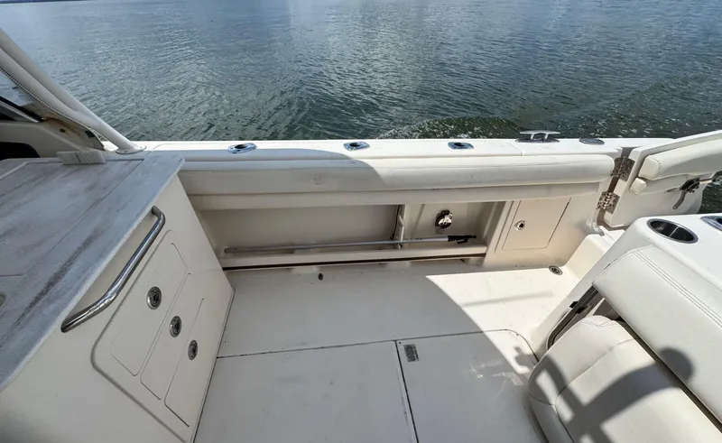Slide: The Image of 2016 Grady-White Freedom 285 boat interior with seating and storage, overlooking calm water. - 12