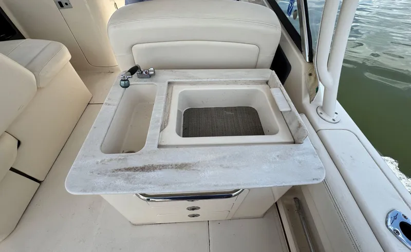 Slide: The Image of 2016 Grady-White Freedom 285 boat interior with sink and seating area. - 14
