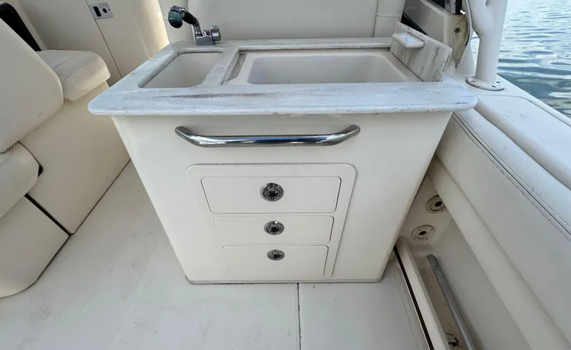 Slide: The Image of 2016 Grady-White Freedom 285 boat interior with sink and storage drawers. - 15