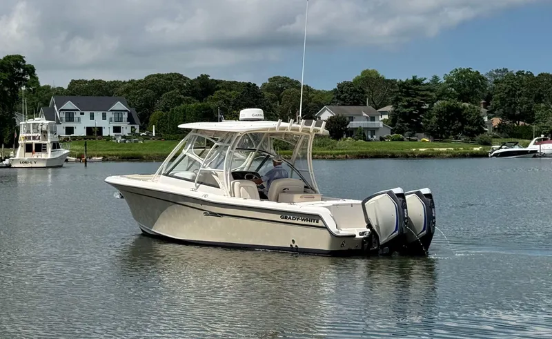 Slide: The Image of 2016 Grady-White Freedom 285 boat on calm water near residential area. - 2