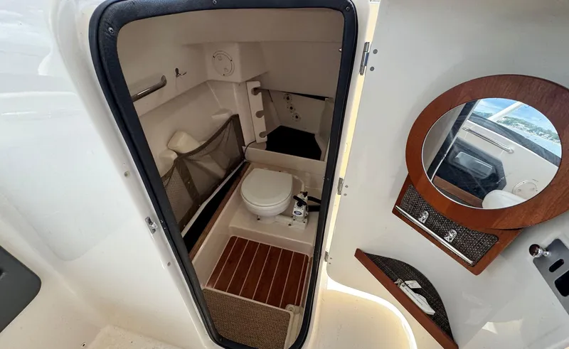 Slide: The Image of 2016 Grady-White Freedom 285 boat interior with compact bathroom and mirror. - 20