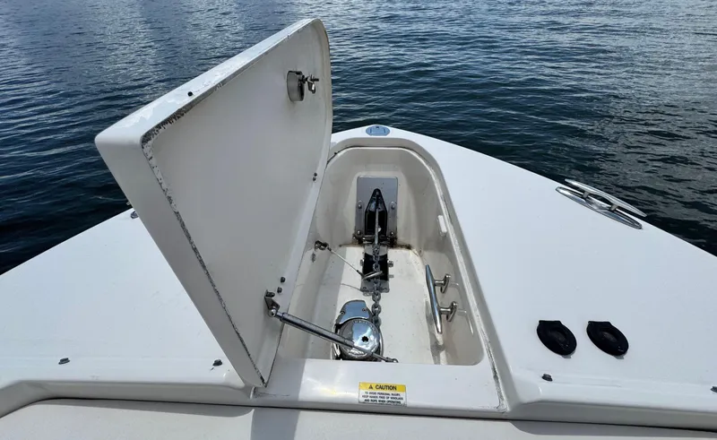 Slide: The Image of Open anchor compartment on 2016 Grady-White Freedom 285 boat, with water in background. - 28