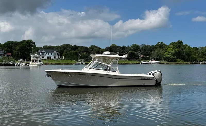Slide: The Image of 2016 Grady-White Freedom 285 boat on a calm lake under a partly cloudy sky. - 4
