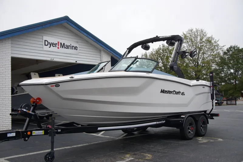Slide: The Image of 2025 MasterCraft NXT23 boat on trailer at Dyer Marine dealership. - 1