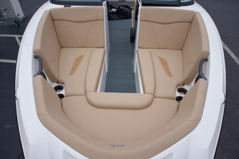 Slide: The Image of 2025 MasterCraft NXT23 boat interior with beige seating and cup holders. - 4