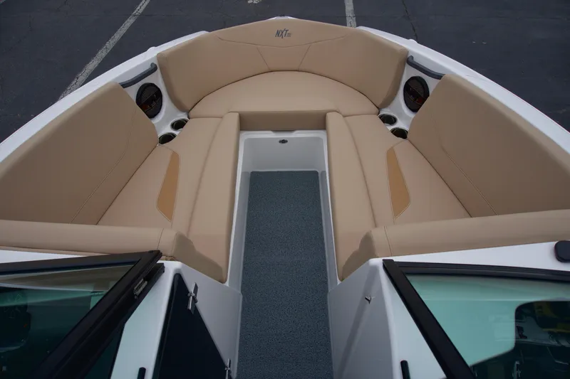 Slide: The Image of 2025 MasterCraft NXT23 boat interior with beige seating and cup holders. - 5