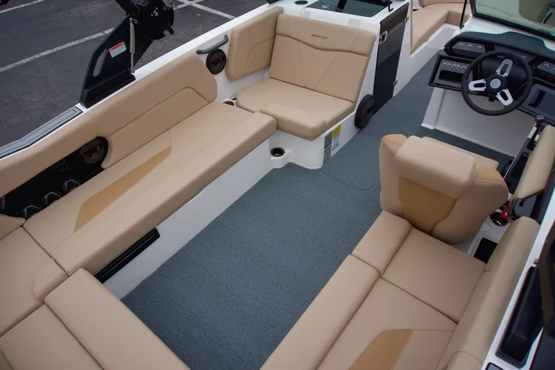 Slide: The Image of 2025 MasterCraft NXT23 boat interior with beige seating and modern dashboard. - 9