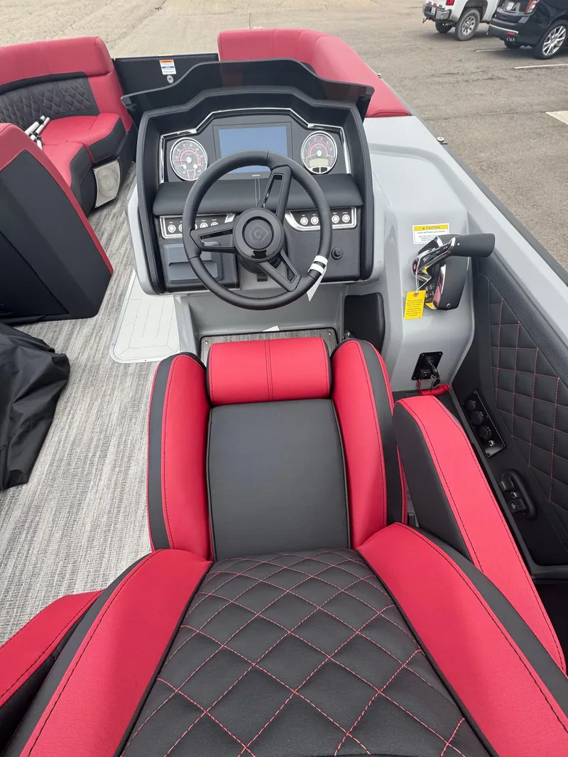 Slide: The Image of 2025 Godfrey AQUAPATIO 255SFL boat interior with red and black seating and modern dashboard. - 13
