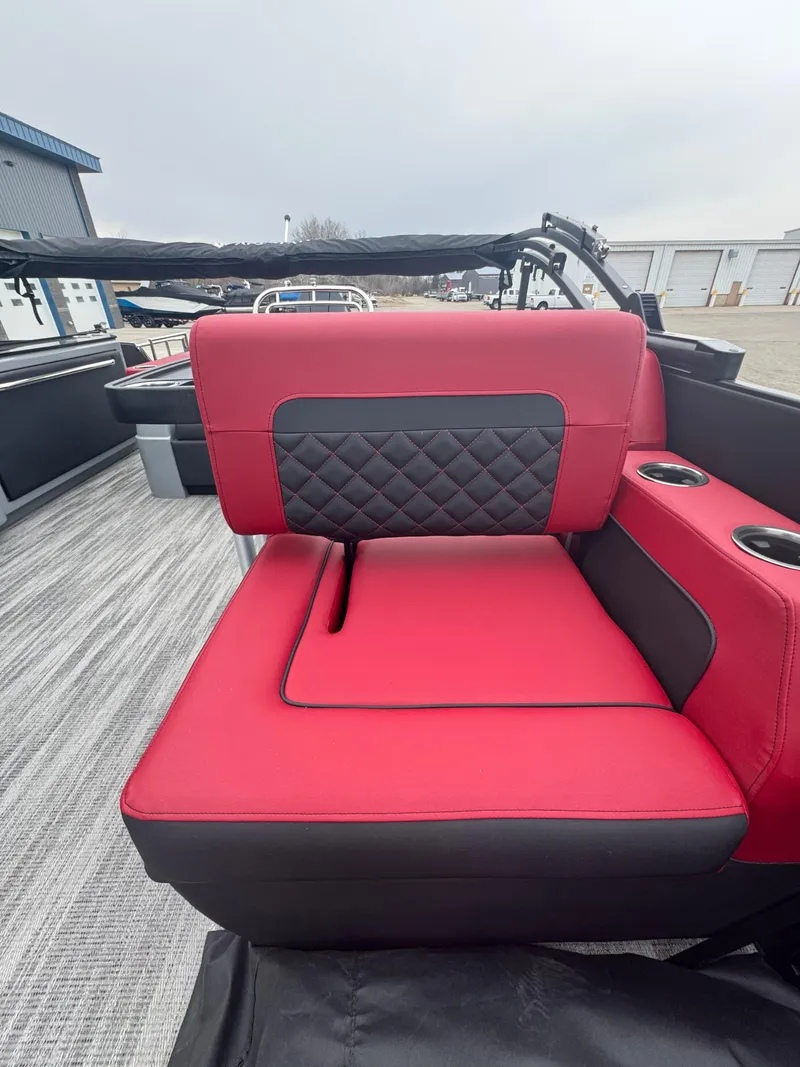 Slide: The Image of Red and black seating on 2025 Godfrey AQUAPATIO 255SFL boat, featuring cup holders and modern design. - 22