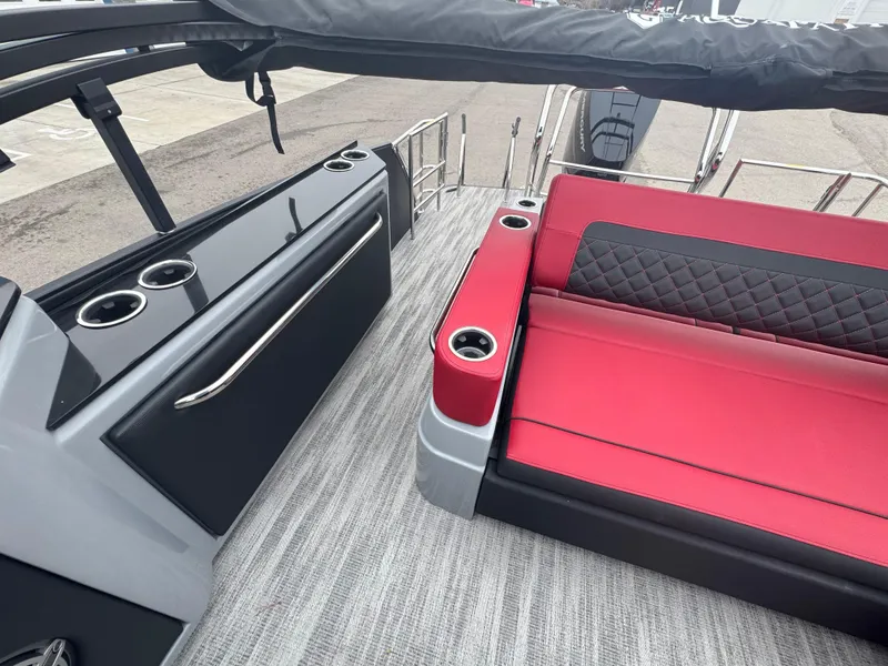 Slide: The Image of 2025 Godfrey AQUAPATIO 255SFL boat interior with red seating and cup holders. - 23