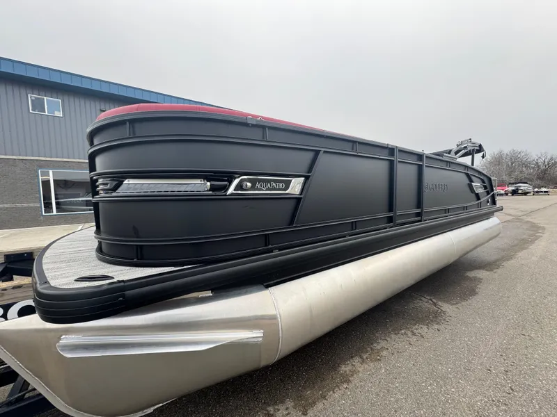 Slide: The Image of 2025 Godfrey AQUAPATIO 255SFL pontoon boat, sleek black design, parked outdoors. - 4
