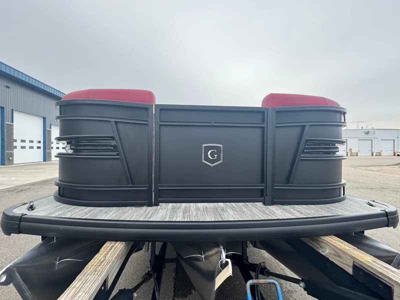 Slide: The Image of 2025 Godfrey AQUAPATIO 255SFL pontoon boat with red seating, docked outdoors. - 5
