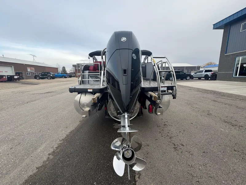 Slide: The Image of 2025 Godfrey AQUAPATIO 255SFL pontoon boat with powerful outboard motor, parked outdoors. - 8