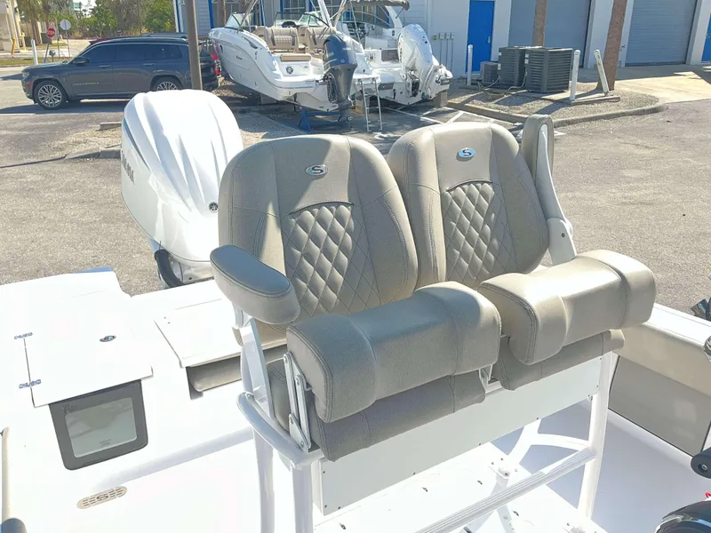 Slide: The Image of Dual captain's chairs on a 2025 Sportsman 247 MASTERS boat, parked outdoors. - 11