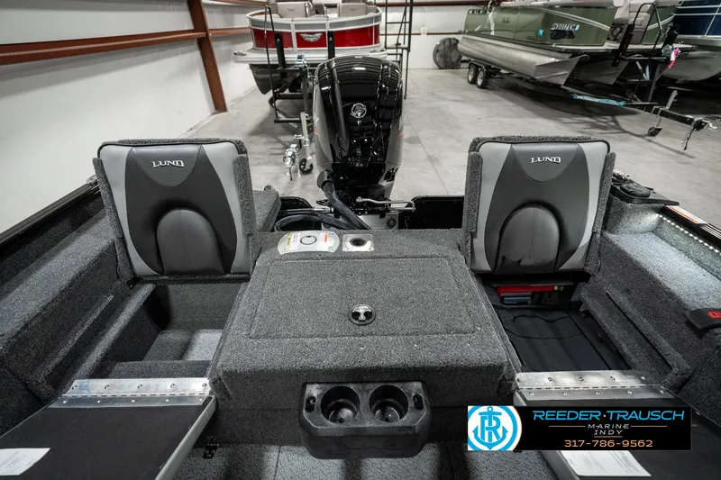 Slide: The Image of 2025 Lund 1775 Adventure Sport boat interior with seating and motor in showroom. - 26
