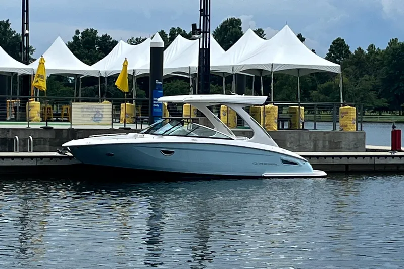 Slide: The Image of 2022 Regal 2800 Bowrider docked by white tents on a calm lake. - 0