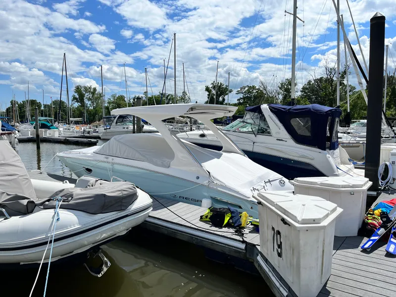 Slide: The Image of 2022 Regal 2800 Bowrider docked at marina with other boats. - 2