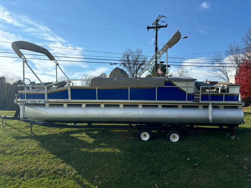 Slide: The Image of 1996 Harris-Kayot Classic 240 O/B pontoon boat on trailer, parked on grass. - 1