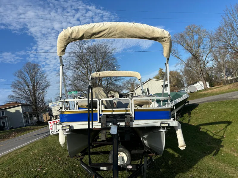 Slide: The Image of 1996 Harris-Kayot Classic 240 O/B pontoon boat on trailer, parked on grass. - 2