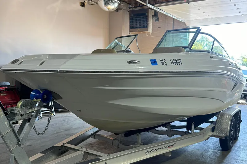 Slide: The Image of 2023 Crownline 215 XS boat on trailer in garage setting. - 12