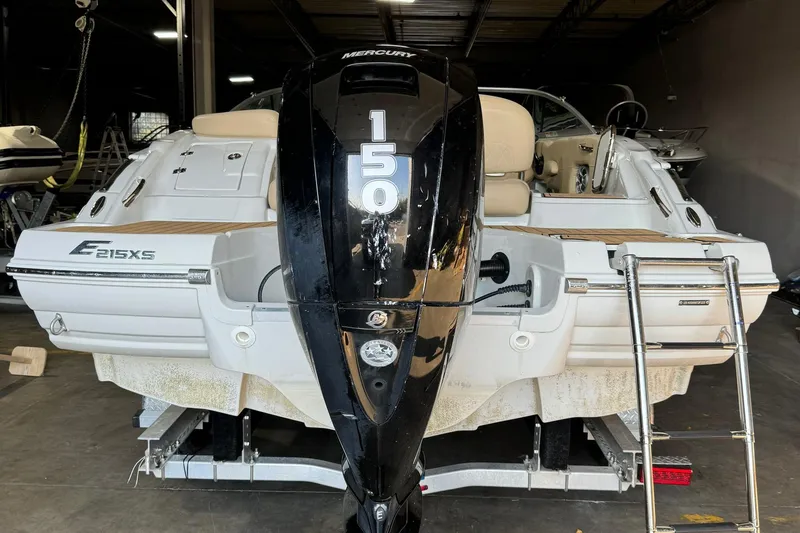 Slide: The Image of 2023 Crownline 215 XS boat with Mercury 150 engine in a garage. - 14