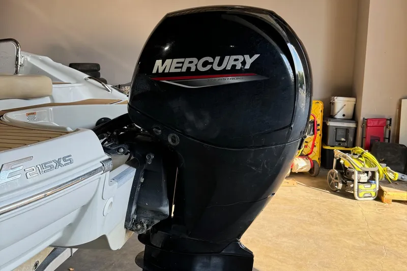 Slide: The Image of 2023 Crownline 215 XS boat with Mercury outboard motor in garage. - 15