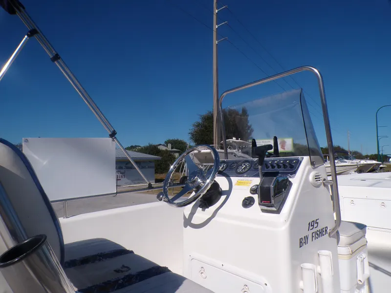 Slide: The Image of 2003 Sea Fox 197 Center Console boat, steering wheel and controls, clear blue sky. - 8