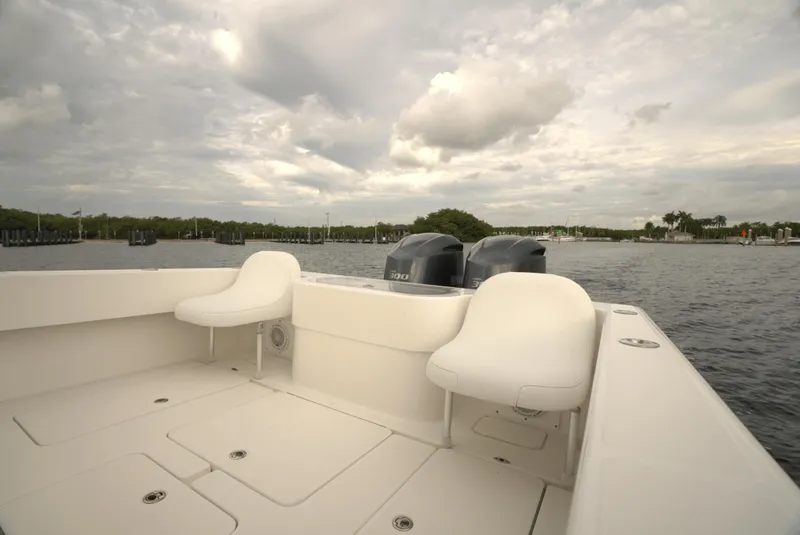 Slide: The Image of 2012 Invincible 33 Open Fisherman boat with dual engines on a calm waterway. - 13