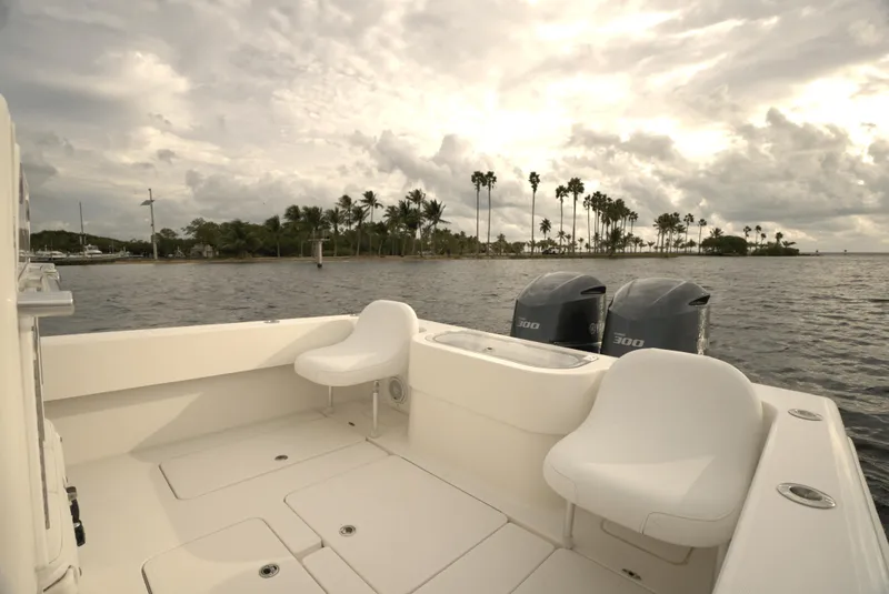 Slide: The Image of 2012 Invincible 33 Open Fisherman boat with dual engines, scenic coastal view. - 14