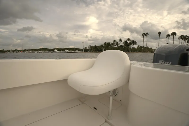 Slide: The Image of Invincible 33 Open Fisherman 2012 boat interior with white seating, ocean view, and cloudy sky. - 17