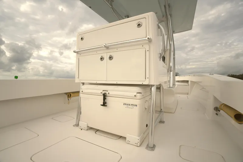 Slide: The Image of 2012 Invincible 33 Open Fisherman boat deck with storage compartments under cloudy sky. - 23